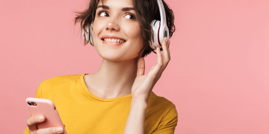 Dziewczyna ze słuchawkami na uszach i ze smartfonem