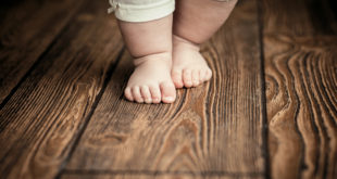 dziecięce stopy na drewnianej podłodze