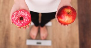 kobieta na wadze wybór między pączkiem a jabłkiem